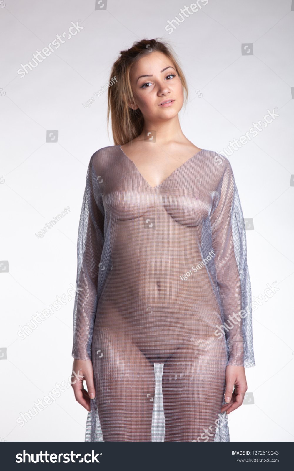 stock-photo-young-beautiful-girl-posing-nude-in-the-studio-standing-in-a-transparent-dress-127...jpg